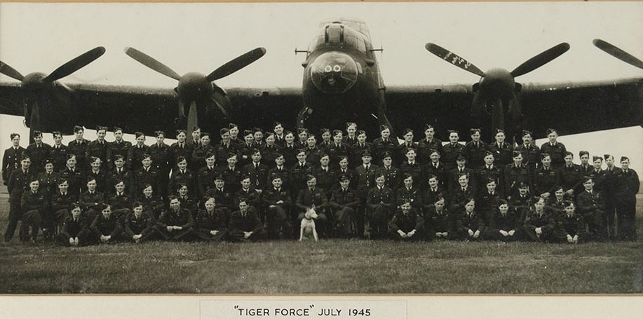 Black and white photo of a squadron of men in front of a Lancaster bomber for Tiger Force