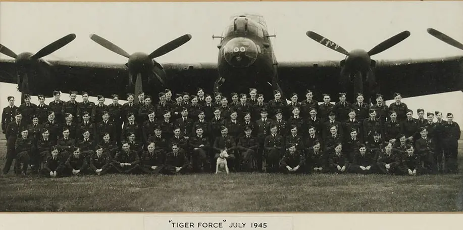 Black and white photo of a squadron of men in front of a Lancaster bomber for Tiger Force